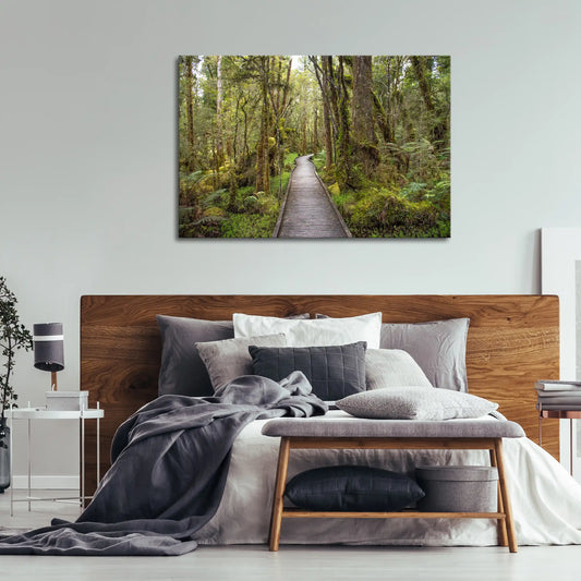 Leinwandbild mit Holzsteg durch dichten Regenwald