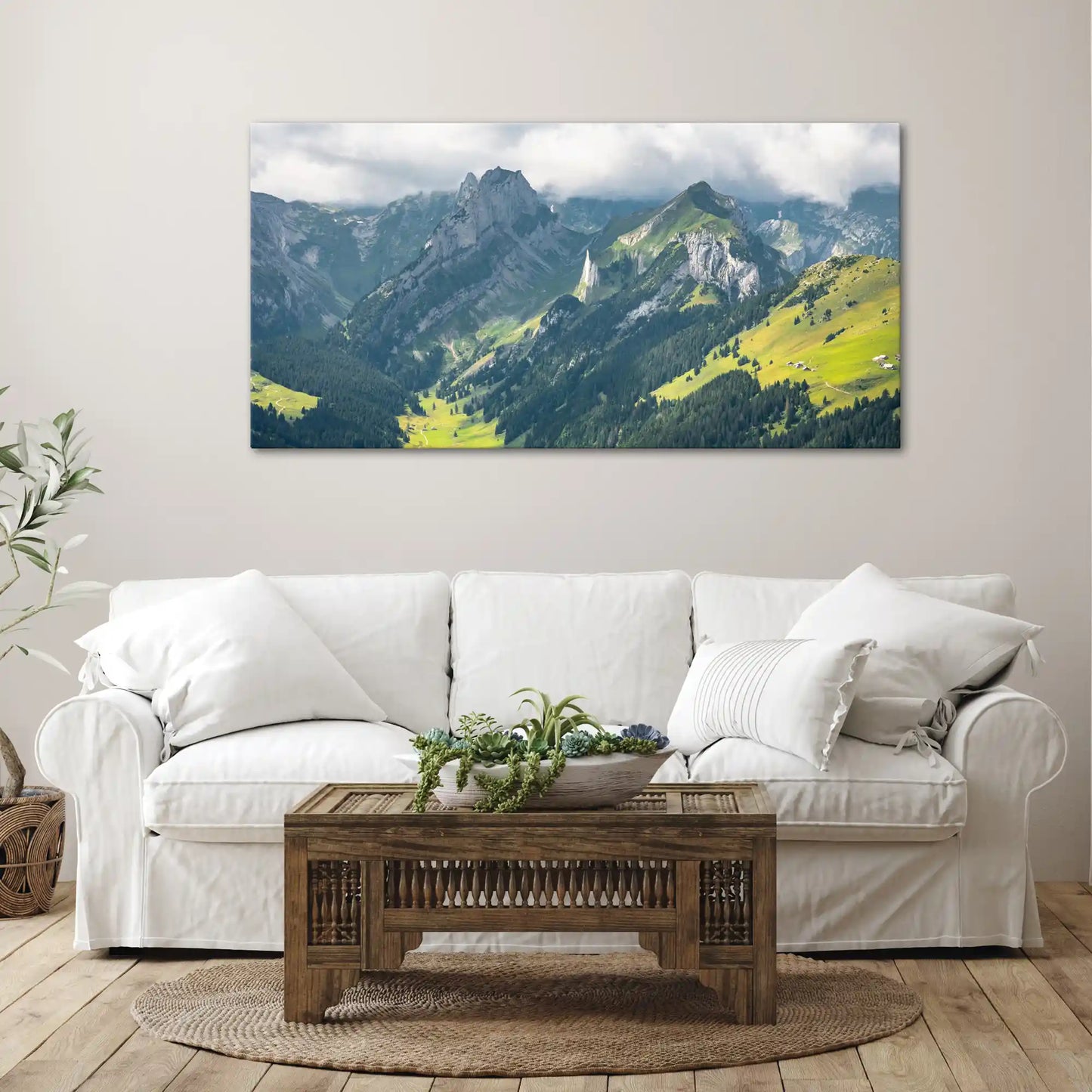 Wandbild Schweizer Alpenlandschaft bei bewölktem Himmel über Couch im Wohnzimmer
