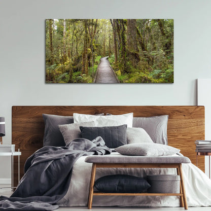Leinwandbild mit Holzsteg durch dichten Regenwald
